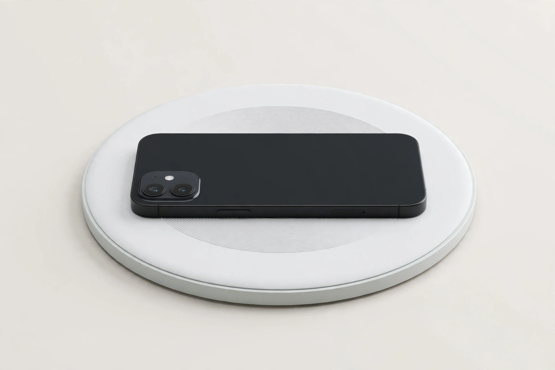 Round wireless charging pad with a phone resting on it on a plain light background