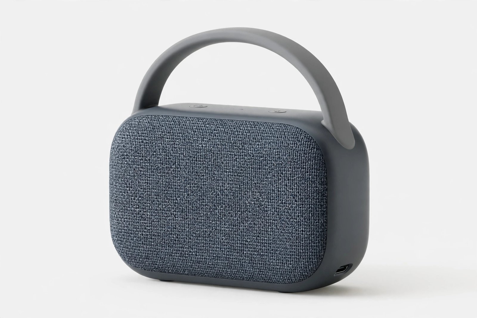Small portable bluetooth speaker with fabric grille and carry handle on a light background