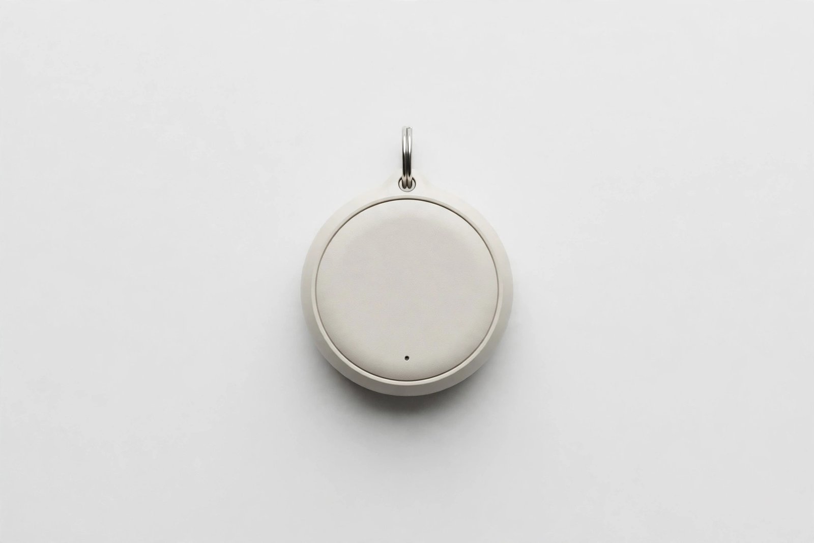 Small round Bluetooth key finder tag on a plain light background