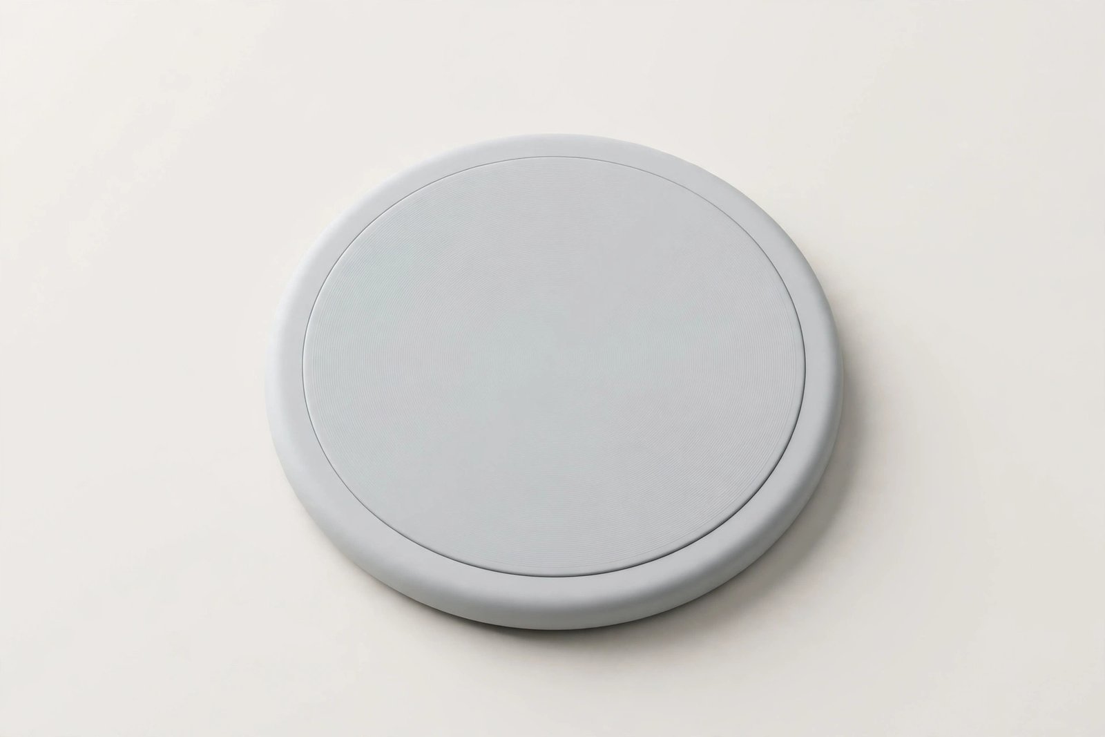 Round wireless charging pad on a plain light background