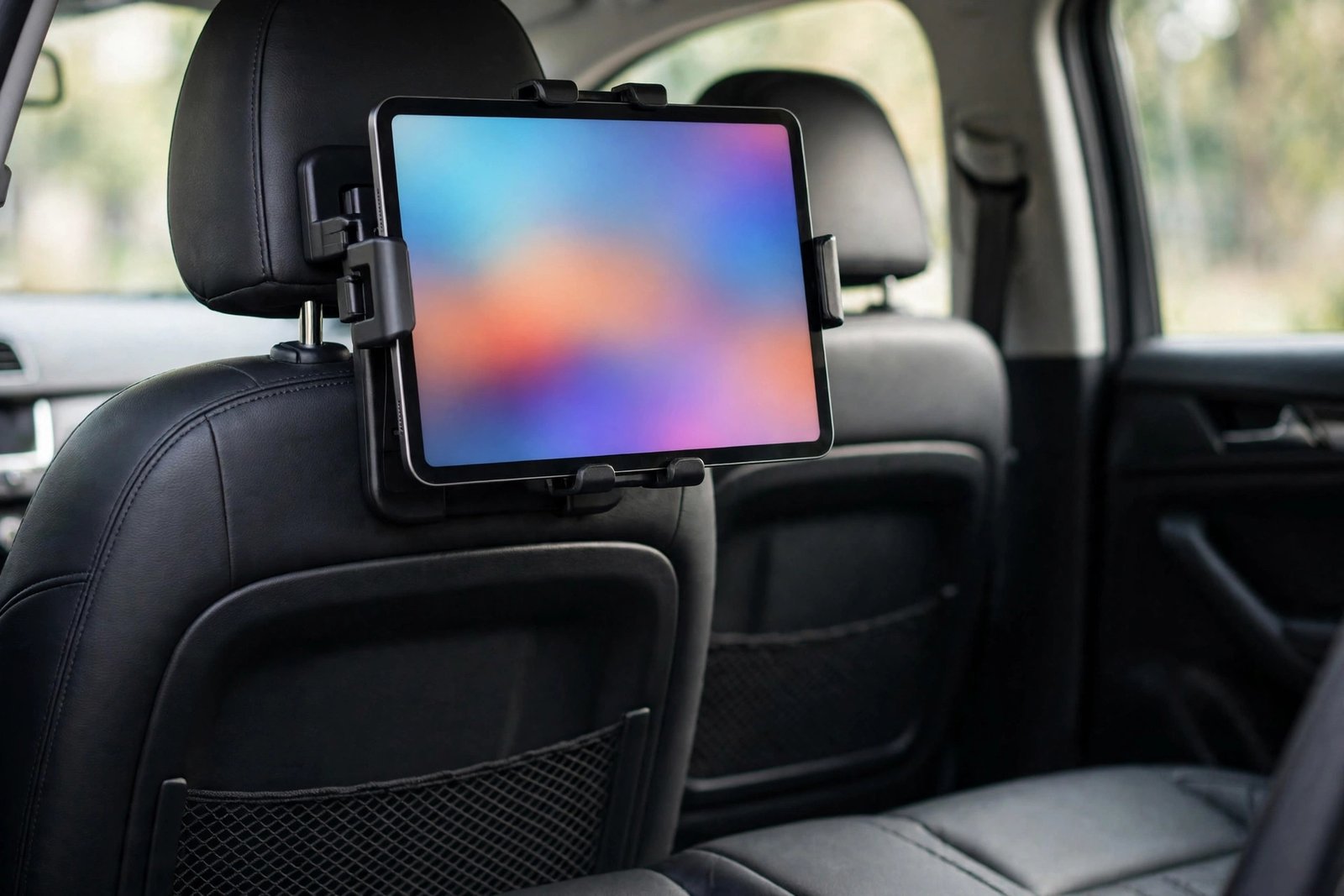 Headrest tablet holder mounted on a car seat headrest holding a tablet for back seat passengers