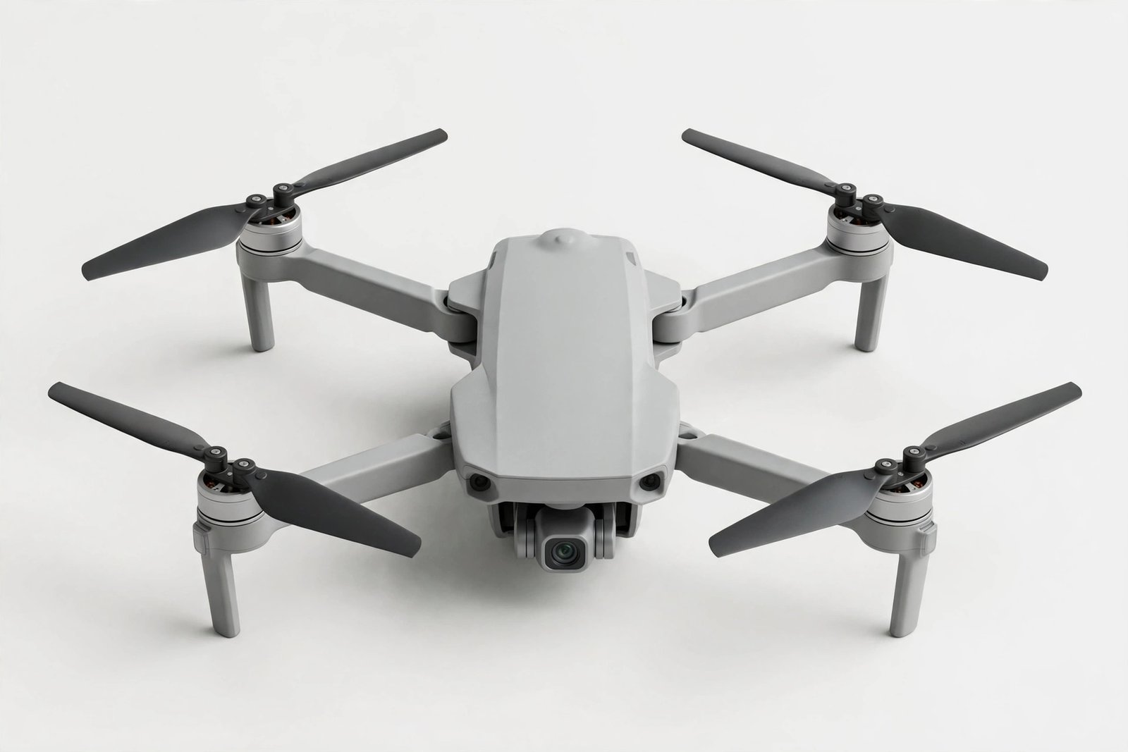 Small foldable camera drone with four propellers on a light background