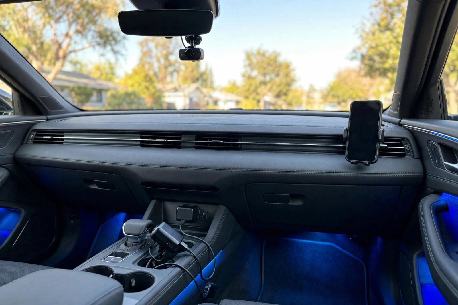 Car interior with practical gadgets for car lovers under $100 — phone mount, dash cam and ambient lighting